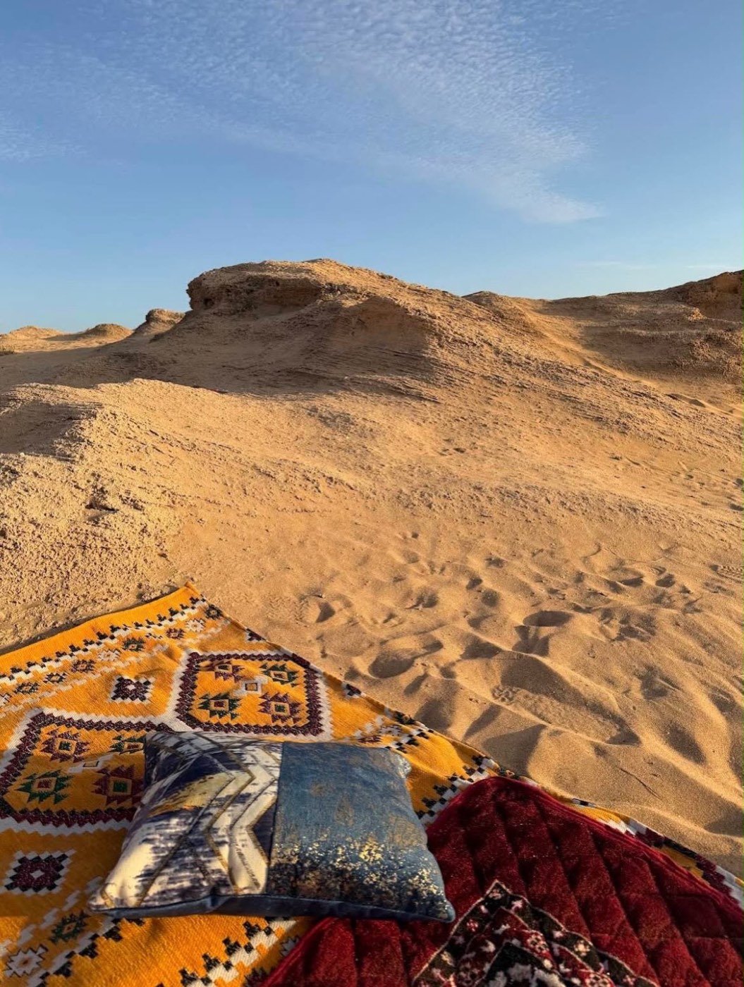 Berber carpet and cushion laid out on the sand dunes