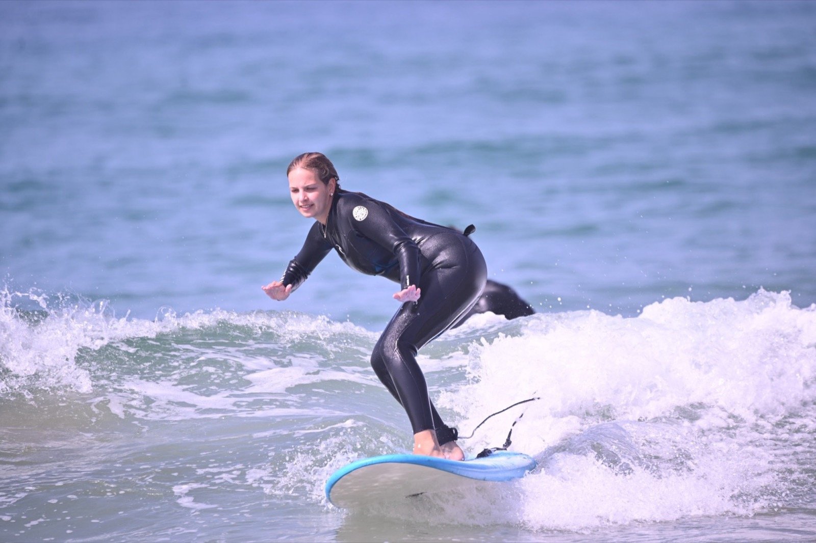Surfista principiante surfeando sus primeras olas durante una clase de surf en Taghazout